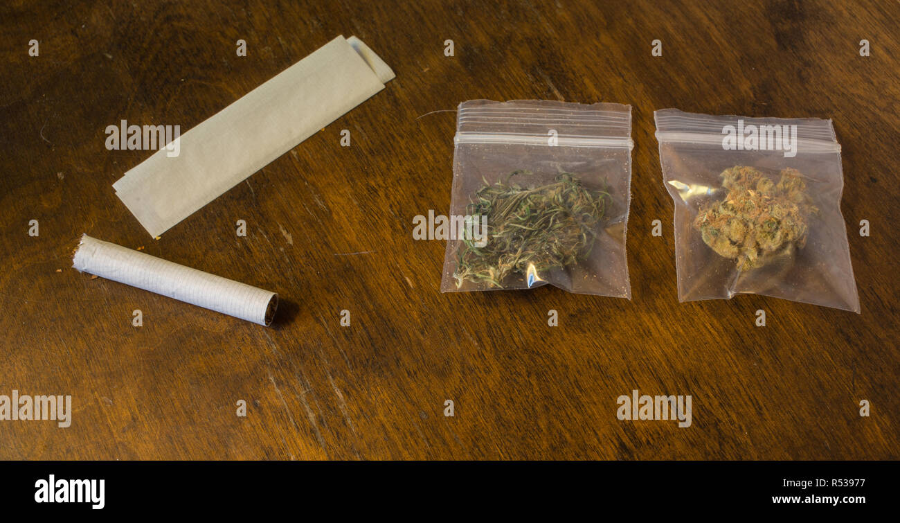 Zwei Beutel mit Cannabis und eine Zigarette und Rolling Paper. Stockfoto