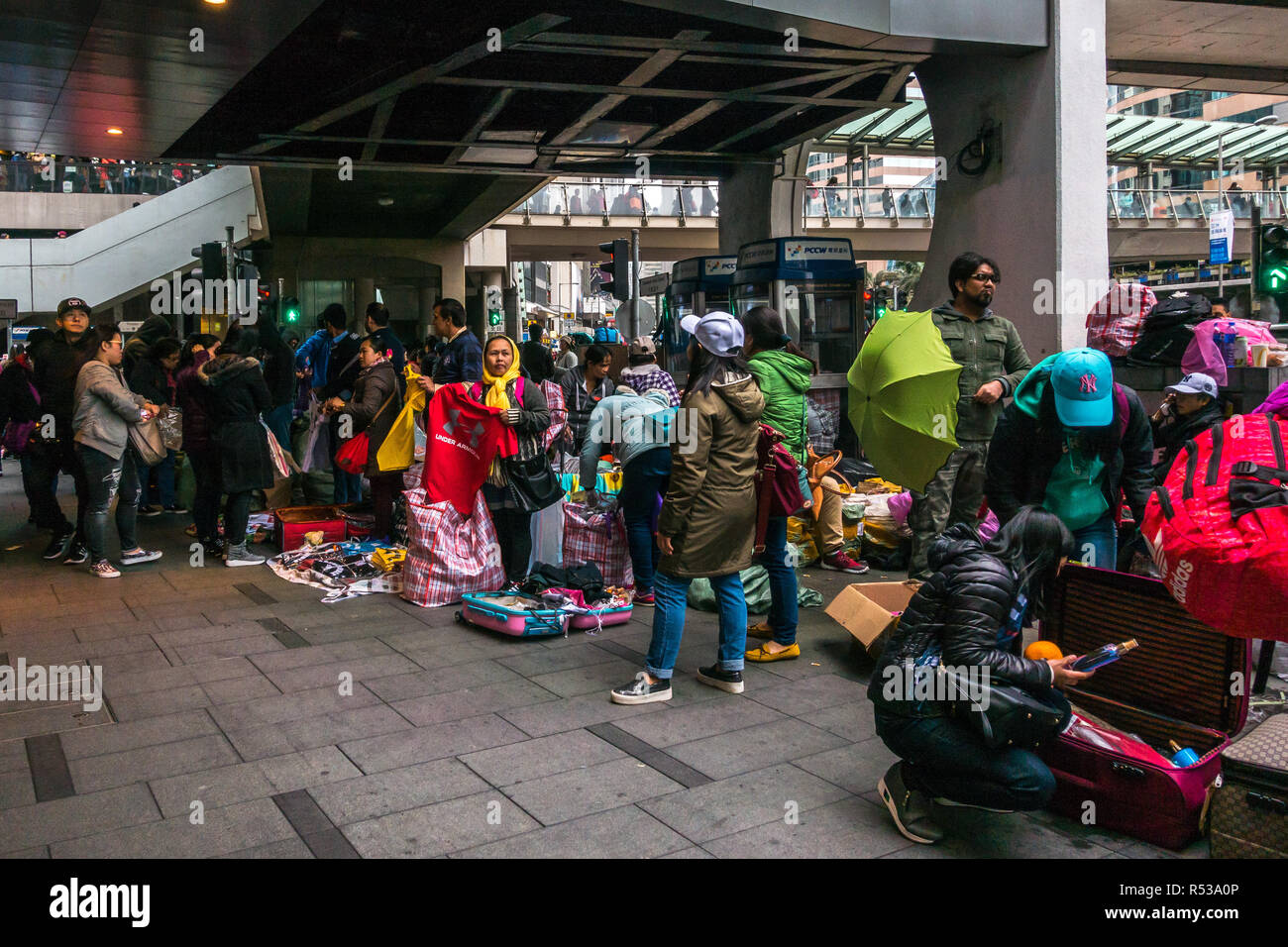Die philippinischen und indonesischen Frauen illegal verkaufen gefälschte Markenkleidung unter einem Gehweg in Hong Kong Central. Hong Kong, Januar 2018 Stockfoto