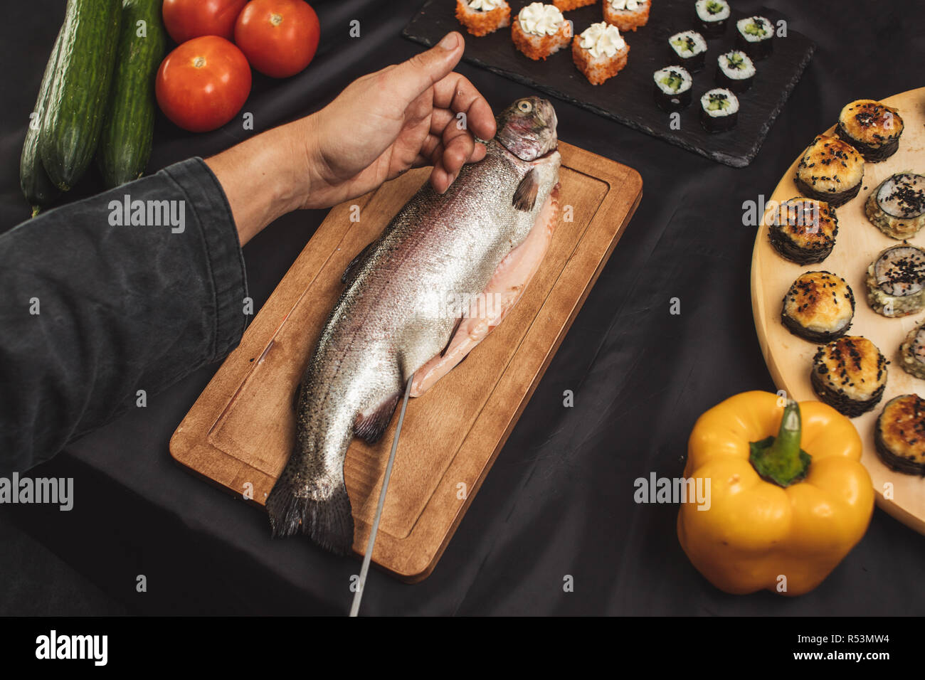 Des Menschen Hände schneiden Fischfilet im Restaurant Stockfoto