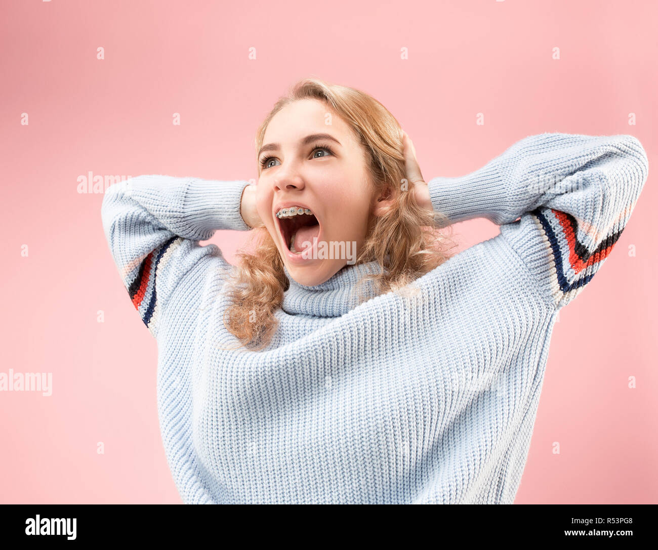 Wow. Schöne weibliche Hälfte - Länge vorne portrait isoliert auf Pink Studio Hintergrund. Junge emotionale überrascht stehende Frau mit offenen Mund. Menschliche Gefühle, Mimik Konzept. Trendige Farben Stockfoto