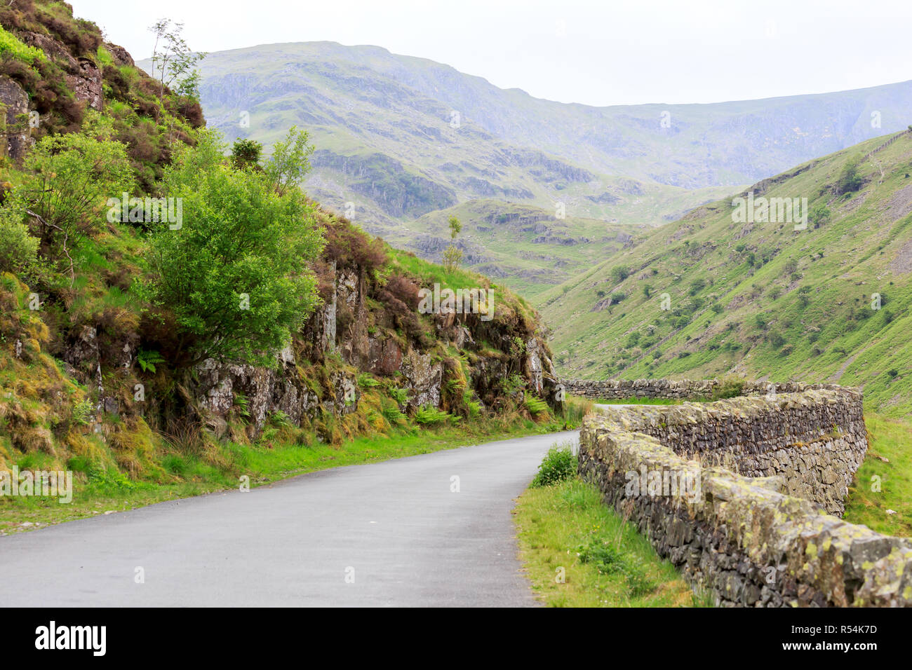 Eine Straße mit einer Steinmauer in die Kumbrischen Bergen gesäumt Stockfoto