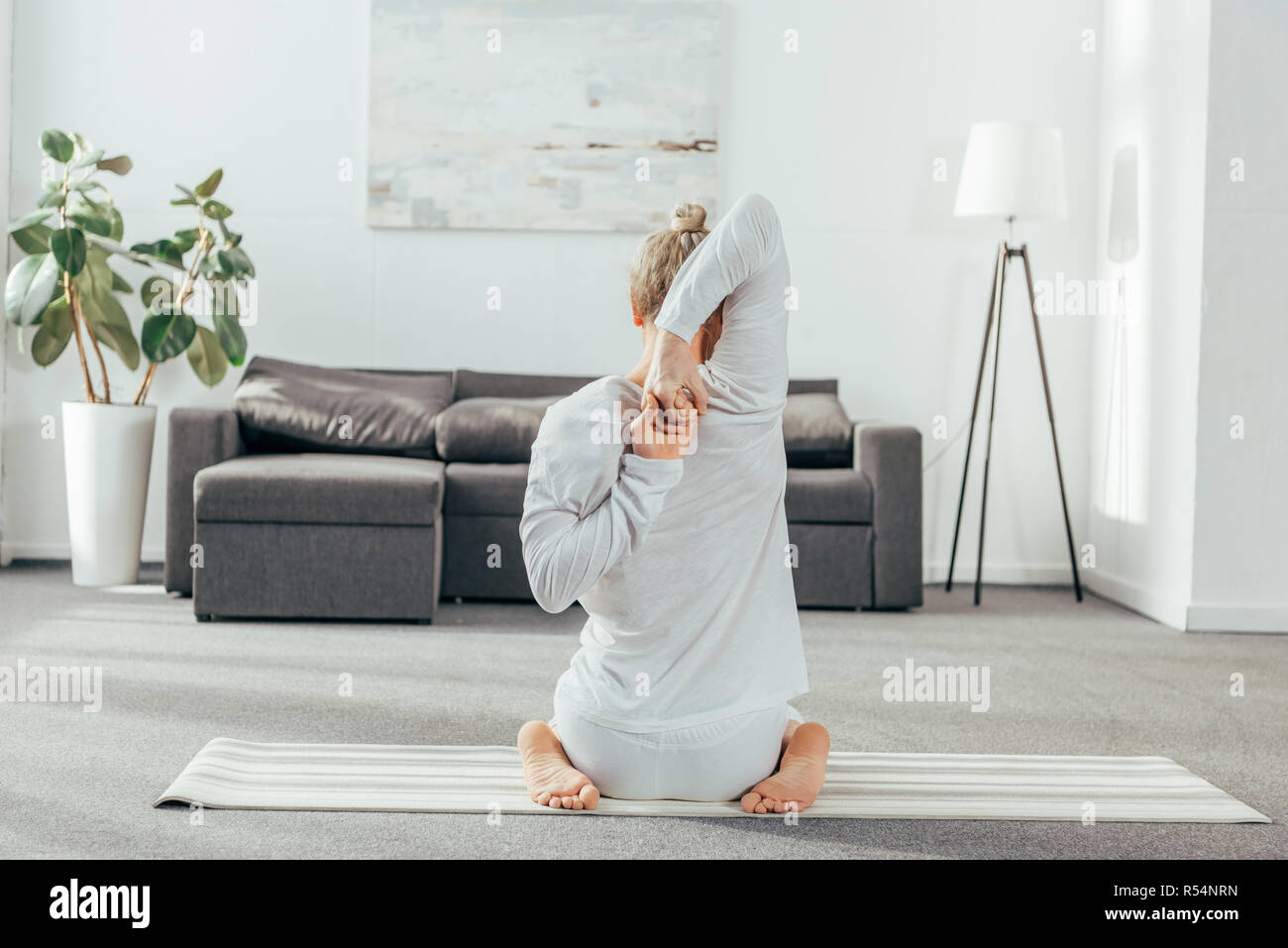 Rückansicht des Menschen üben Yoga mit den Händen hinter dem Rücken zu Hause Stockfoto