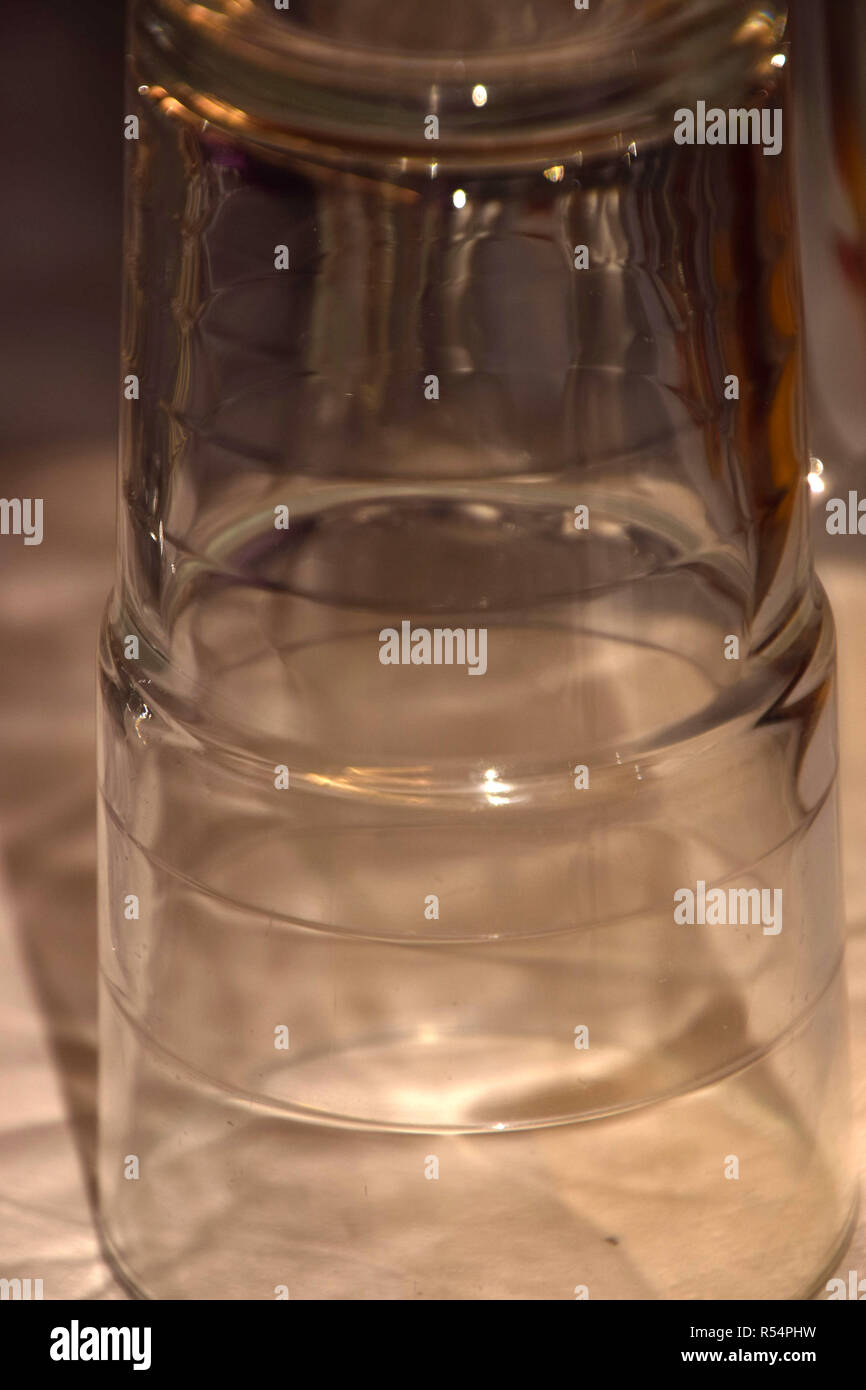 Detail Schoß der einzigen Wasser Glas, klares Wasser Gläser sind Kopf und schillern in den warmen goldenen Glanz Makroaufnahme Stockfoto