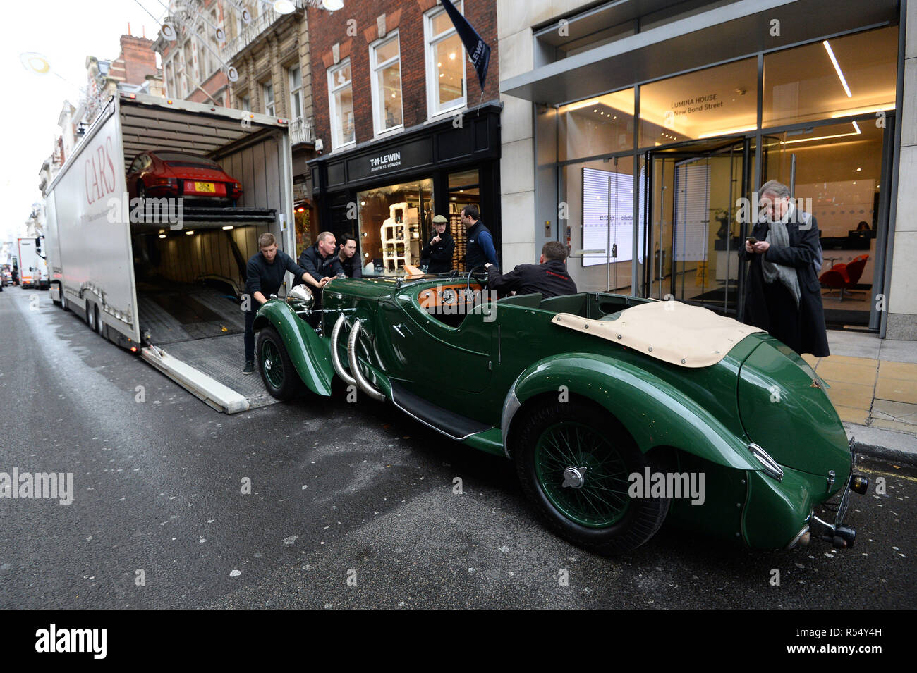 Auktionshaus Assistenten ein 1937 Lagonda LG45 Rapide Tourer, während ein Foto Aufruf für &pound Entladen; 20 m Supercars, bevor Sie an der Auktion angeboten werden, bei Bonhams in New Bond Street, London. Stockfoto