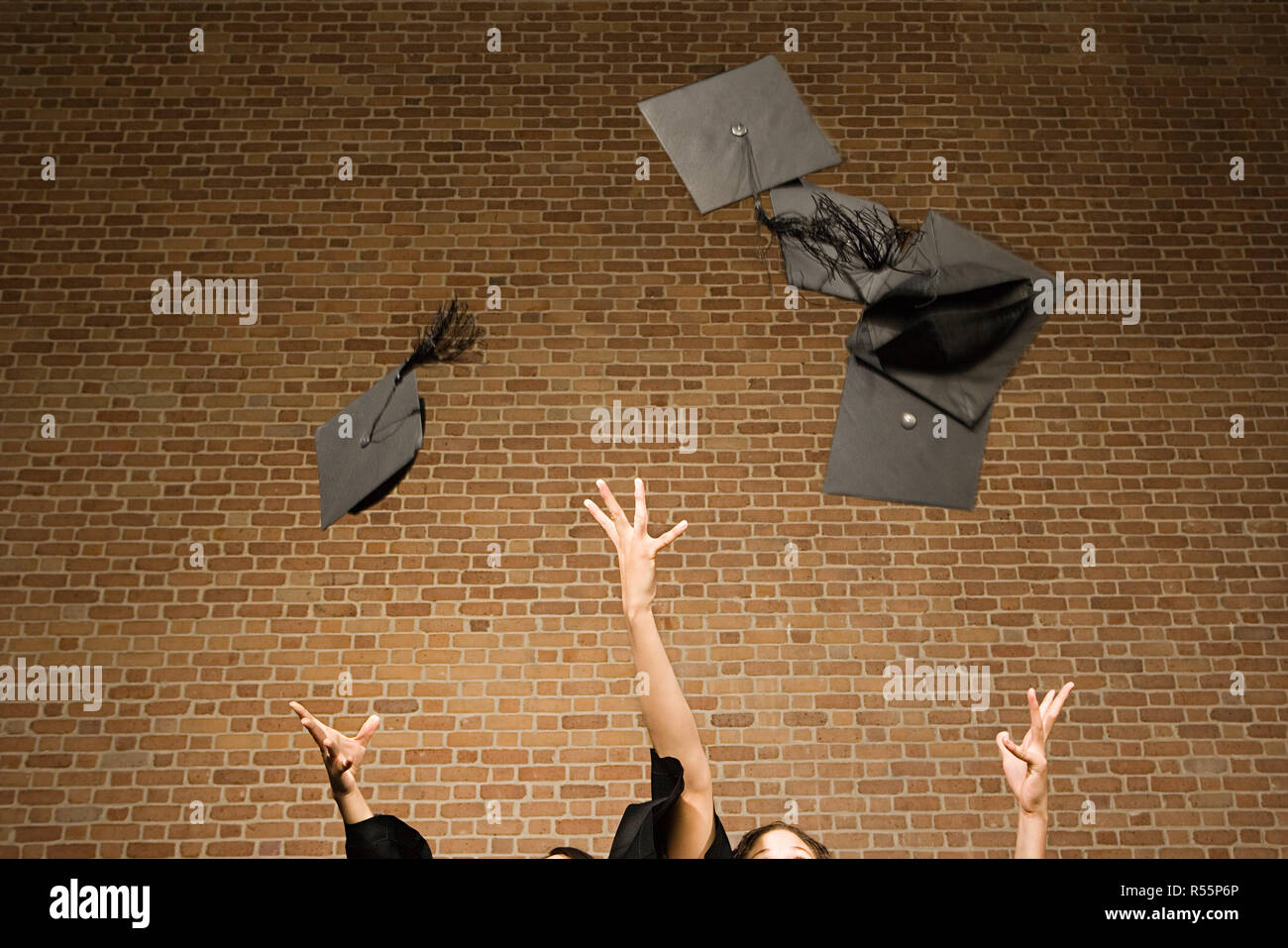 Absolventinnen und Absolventen werfen ihre Mörtel-boards Stockfoto
