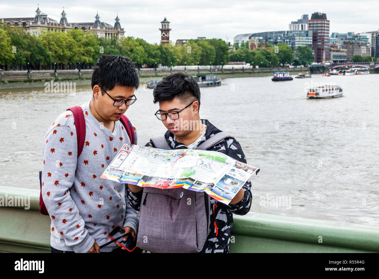 London England, Großbritannien, Westminster Bridge, Themse River, asiatischer Mann Männer männlich, junge Jungen, Kinder Kinder Kinder Jugendliche, Teenager Teenager Jugendliche lesen Stockfoto