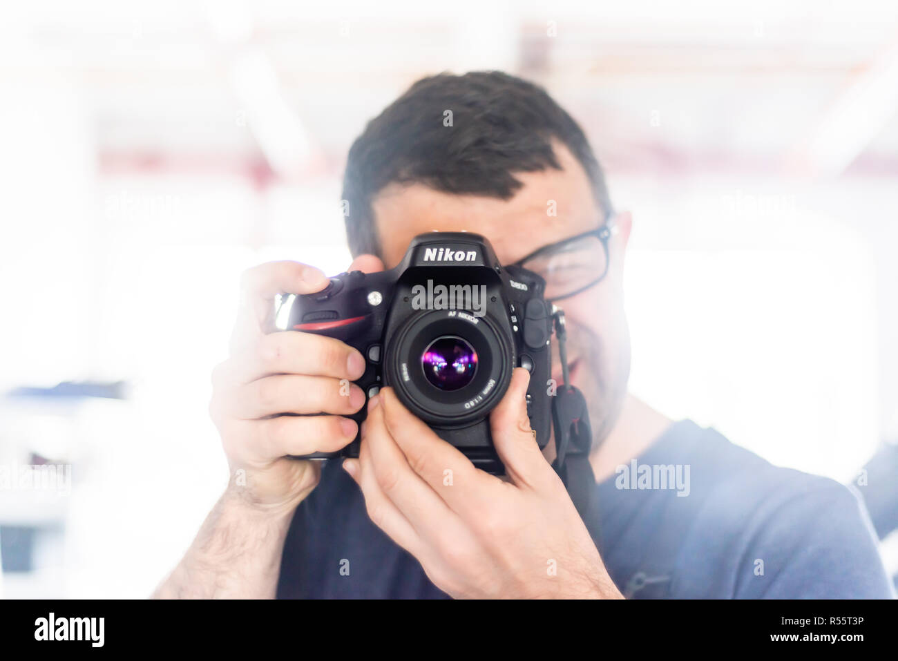 Reflektion von einem Mann mit einer Nikon D800 Kamera mit einem 50-mm-Objektiv im Spiegel Stockfoto