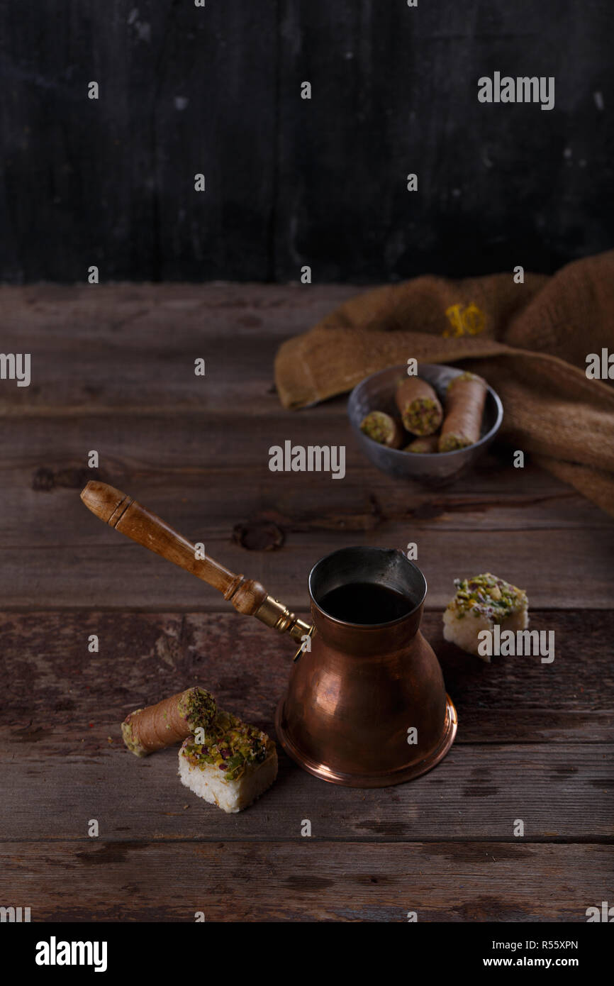 Traditionelle türkische Kaffeekanne mit orientalischen Süßigkeiten, Kopie Raum dunkel Foto Stockfoto