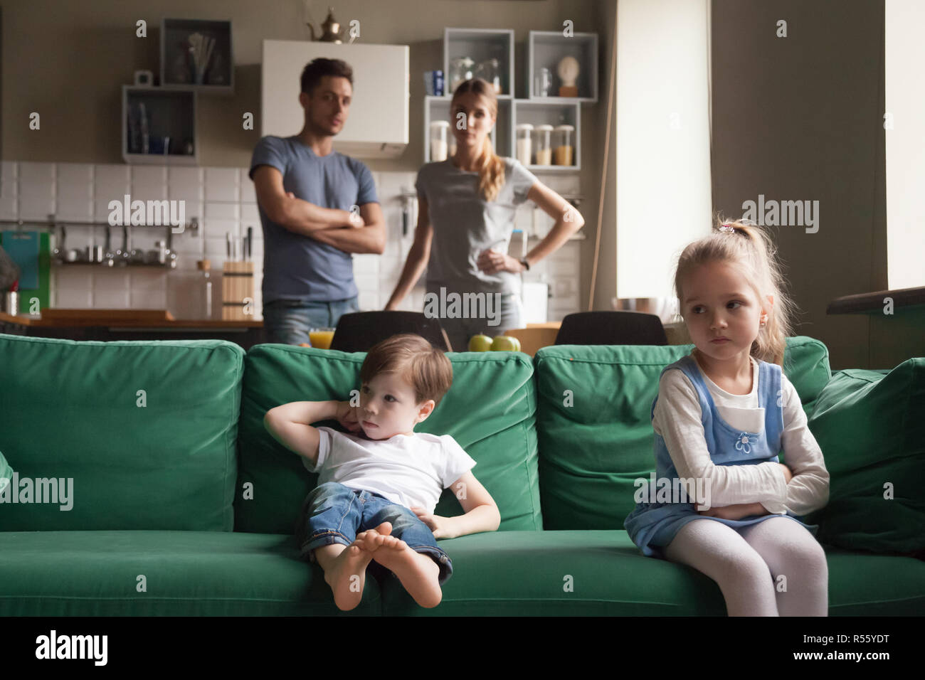 Beleidigt, Schwester, Tochter sitzen auf der Couch mit Bruder umgekippt Stockfoto
