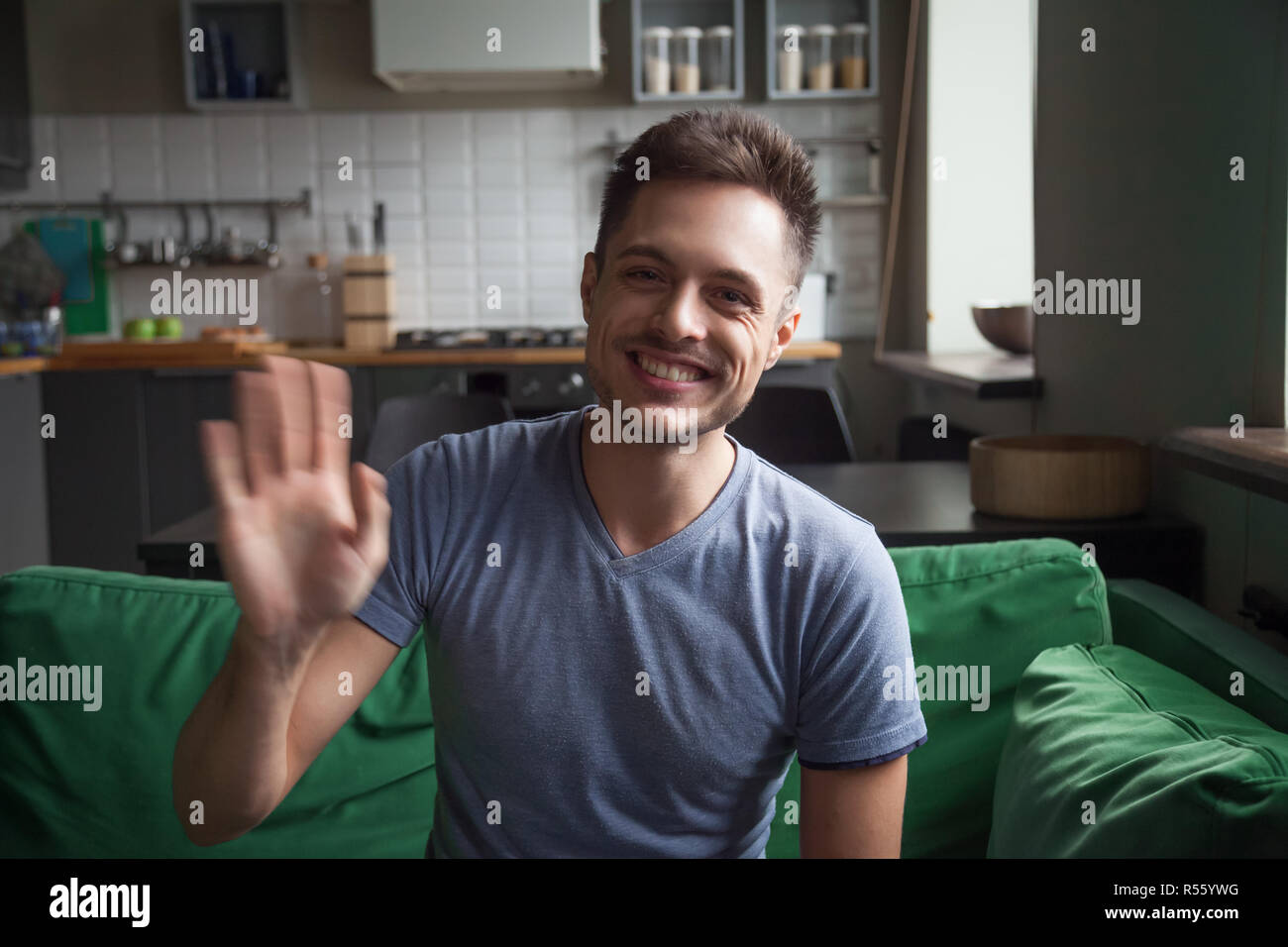 Portrait glücklich lächelnde Mann Hand winken, mit Blick auf die Kamera Stockfoto