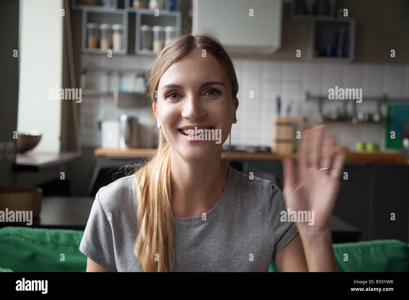 Portrait glücklich lächelnde Frau Hand winken, mit Blick auf die Kamera Stockfoto