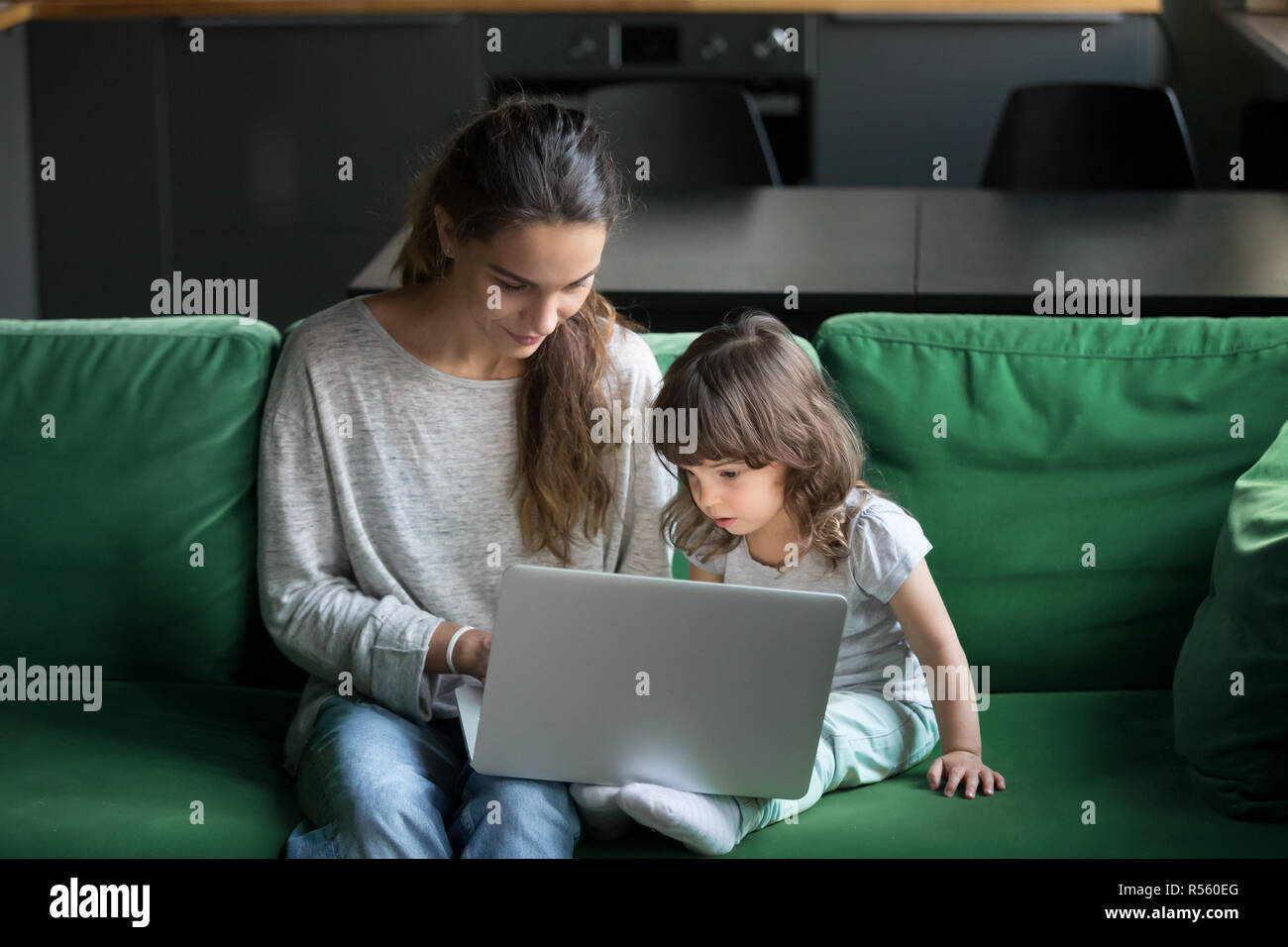 Alleinerziehende Mutter mit Laptop zusammen mit Tochter Stockfoto