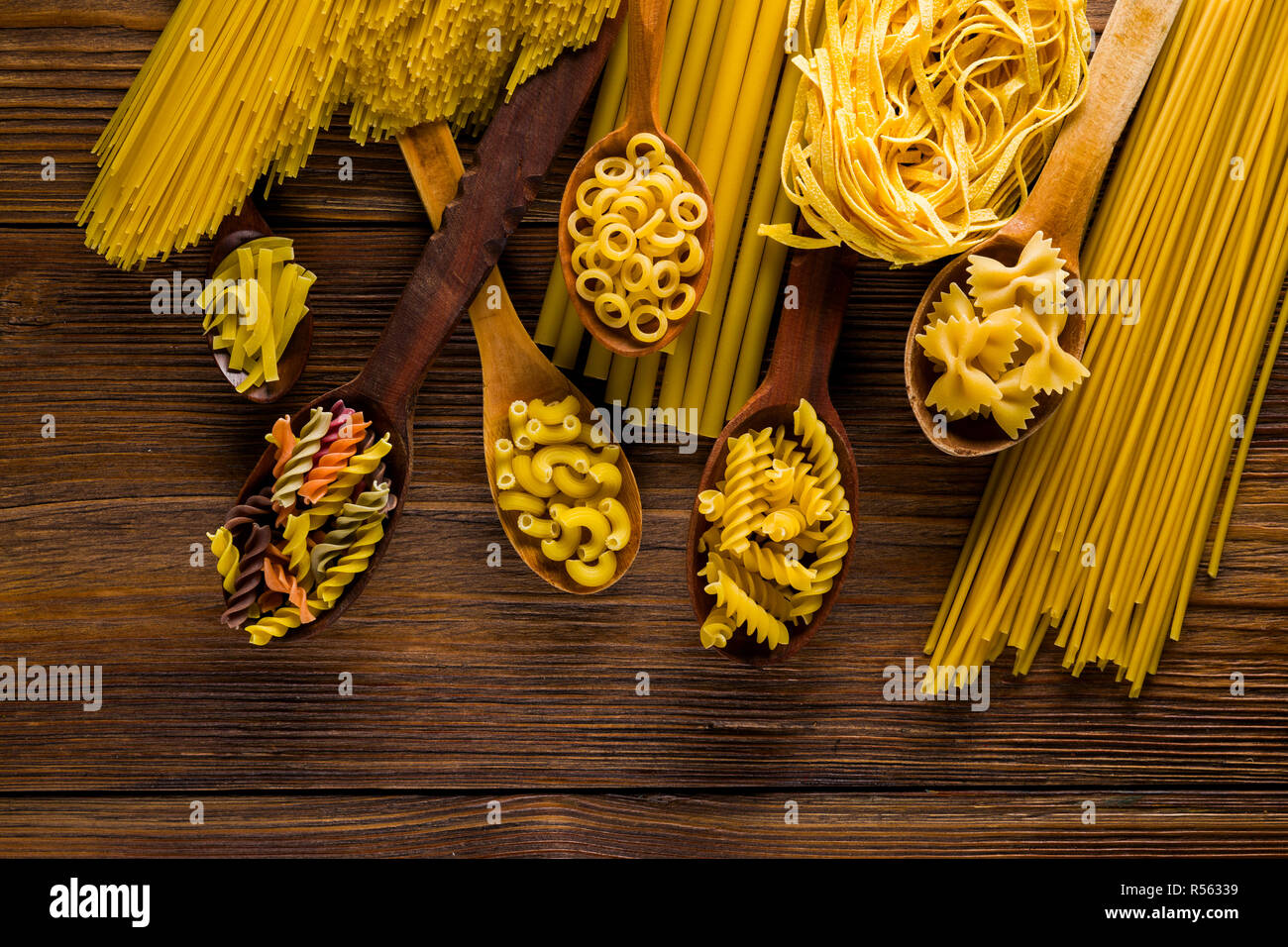 Eine Vielzahl an raw Nudeln und Spaghetti auf hölzernen Löffel Stockfoto