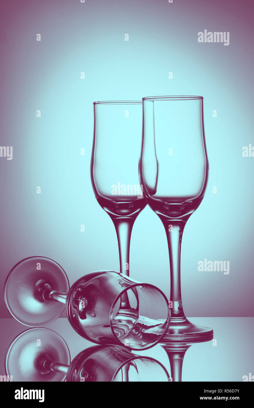 Drei leere Champagner Gläser mit farbigem Hintergrund mit Reflexion. Werbung Bild Kunst getönt Stockfoto