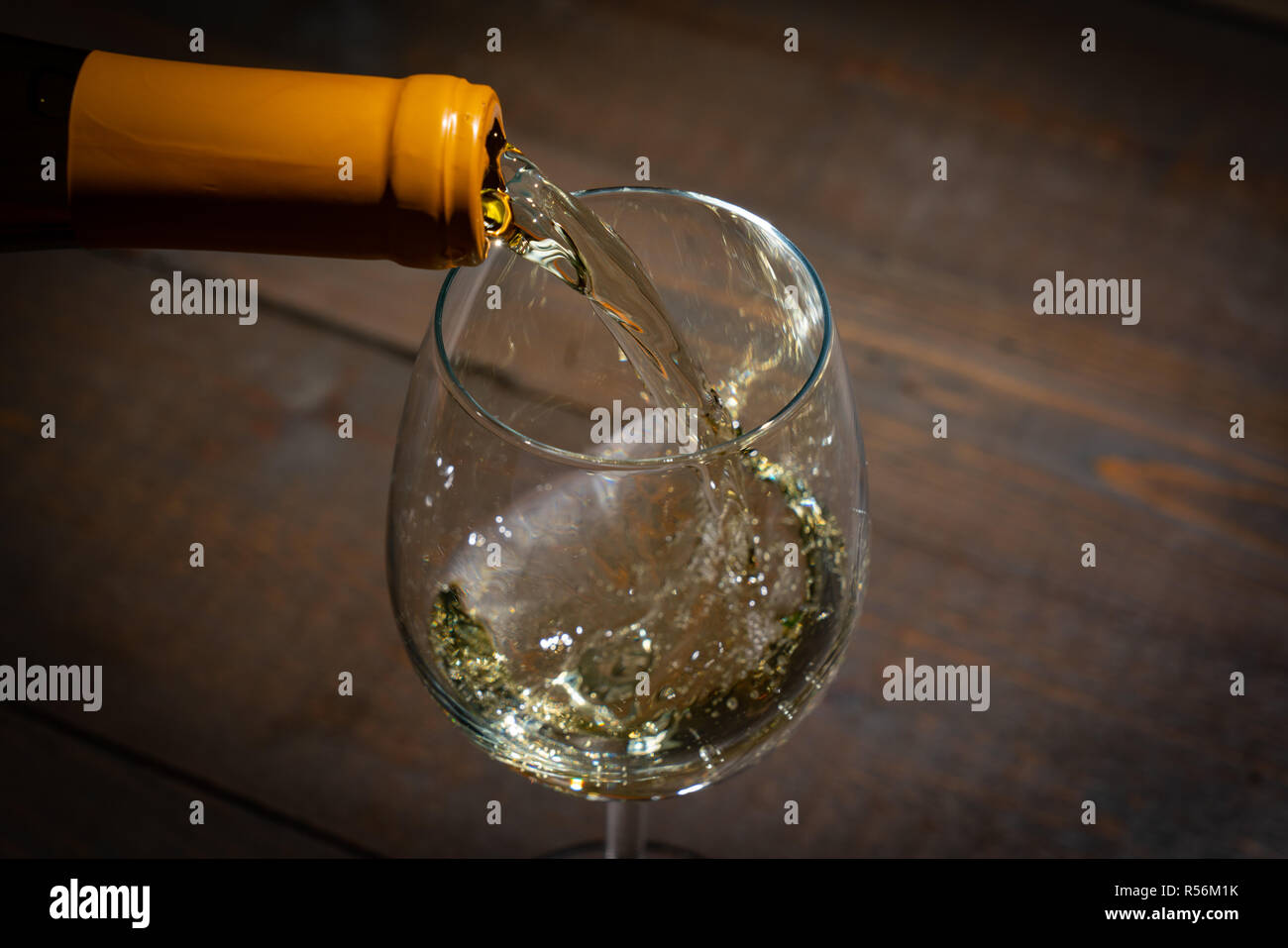 Rotwein Gießen in einem Weinglas aus der Flasche Stockfoto