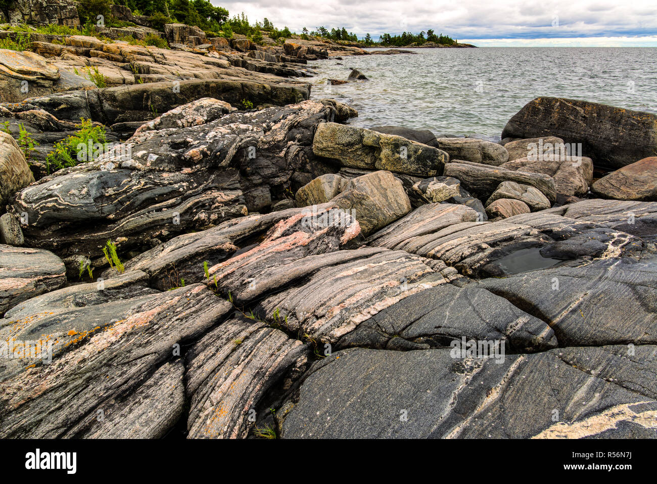 Multibanded Gneis Felsen an der Küste einer Insel unter den 30.000 - Insel Archipel der Georgian Bay, Ontario, Kanada. Die Felsen sind ein Teil der Stockfoto