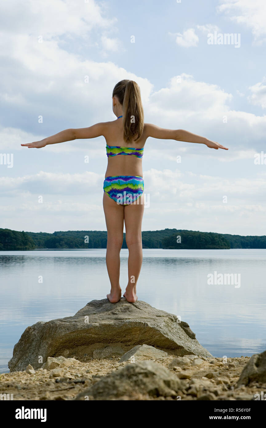 Mädchen stehen auf Felsen See Stockfoto