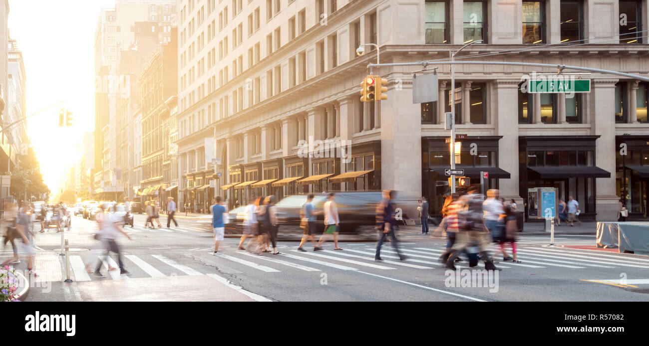 New York City street scene mit Massen von Menschen zu Fuß in Midtown Manhattan und Sonnenlicht Hintergrund Stockfoto