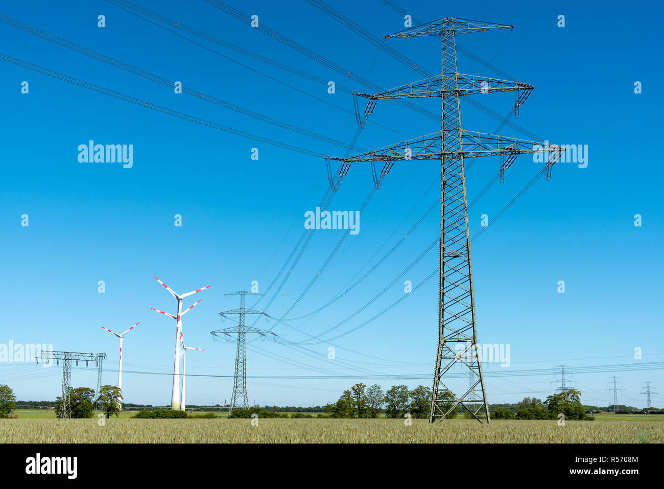 Stromleitungen mit einigen Windenergieanlagen in Deutschland Stockfoto