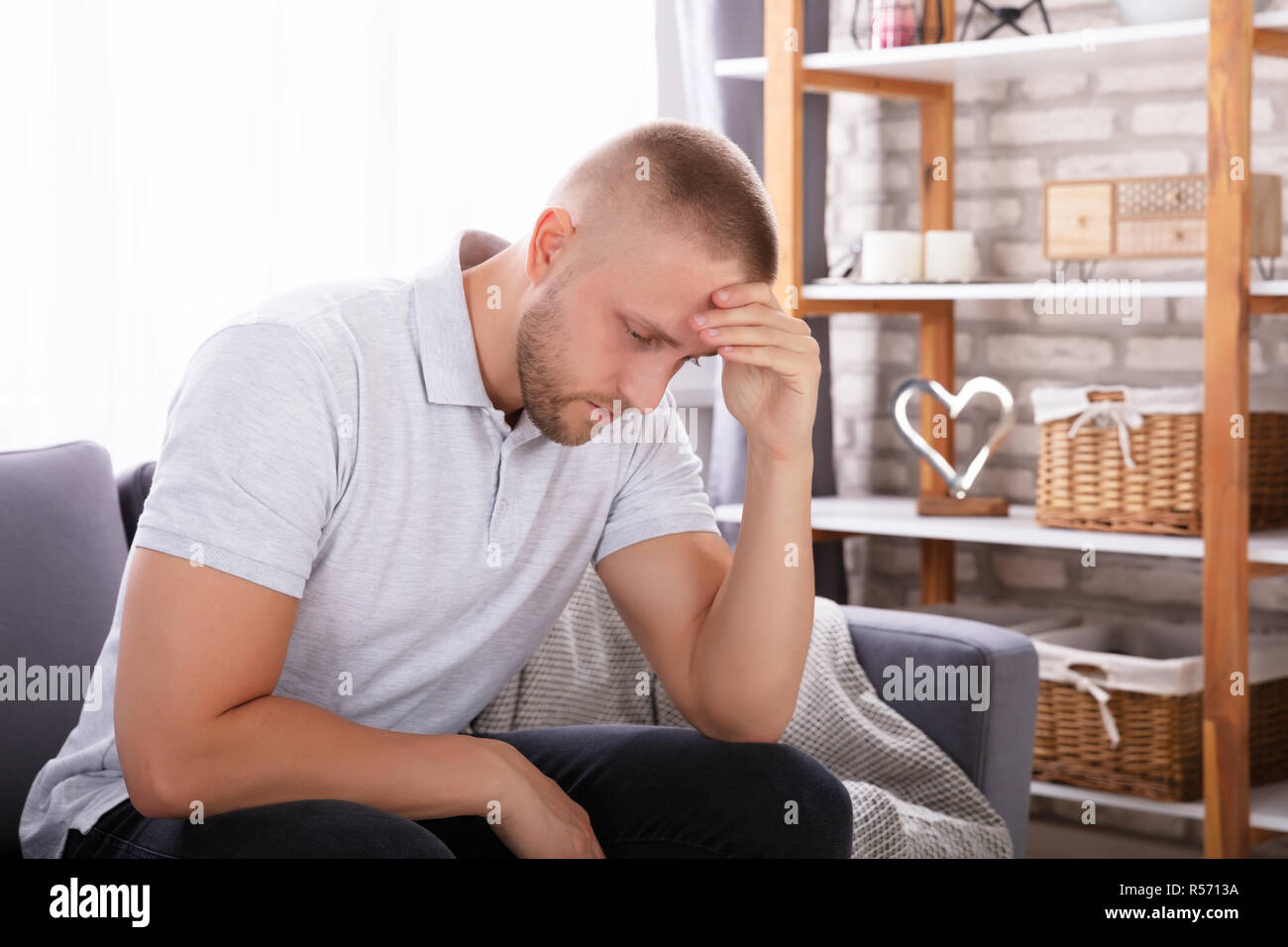 Seitenansicht eines umgekippten Junge Mann sitzt auf einem Sofa Stockfoto