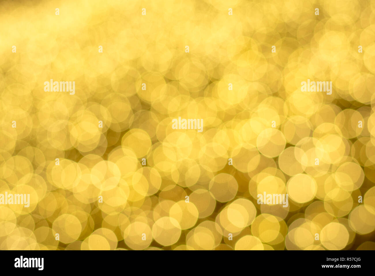 Weihnachtsbeleuchtung verschwommen in Bokeh auf einem gelben Feld. Stockfoto