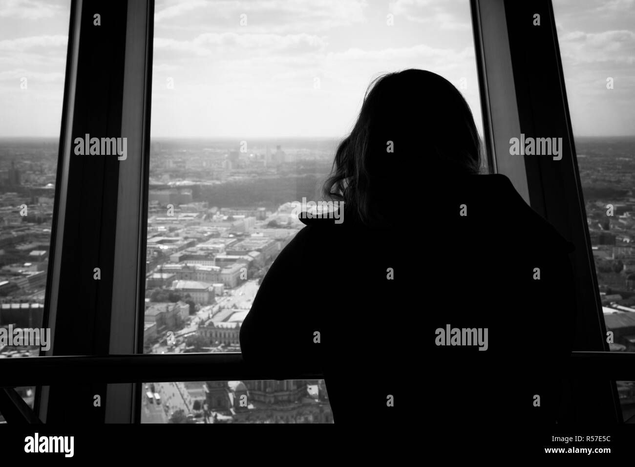 Silhouette von Rückseite der Frau durch ein Fenster in der Berliner City Skyline Stockfoto