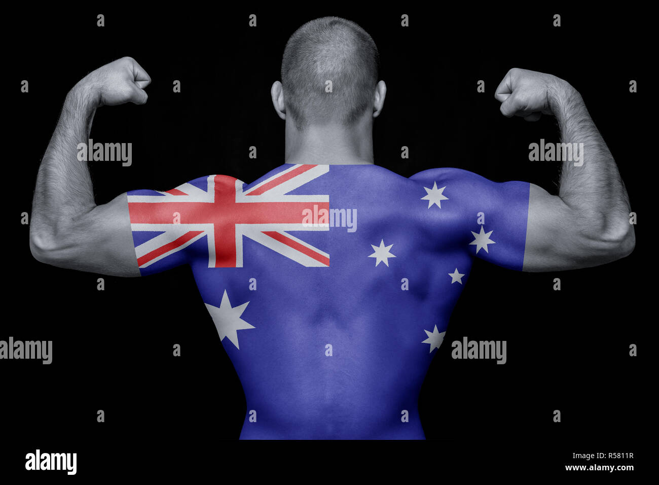 Die Rückseite eines jungen athletischen Mann, der ein T-Shirt mit der nationalen Flagge Australien auf einem schwarzen Hintergrund isoliert. Das Konzept der nationalen Stolz ein Stockfoto