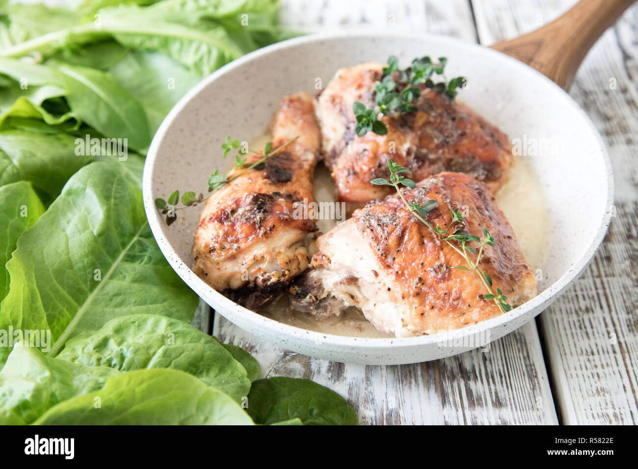 Golden gebratene Hühnerkeule mit Gewürzen und Kräutern. Gebackene Hähnchenschenkel Stockfoto