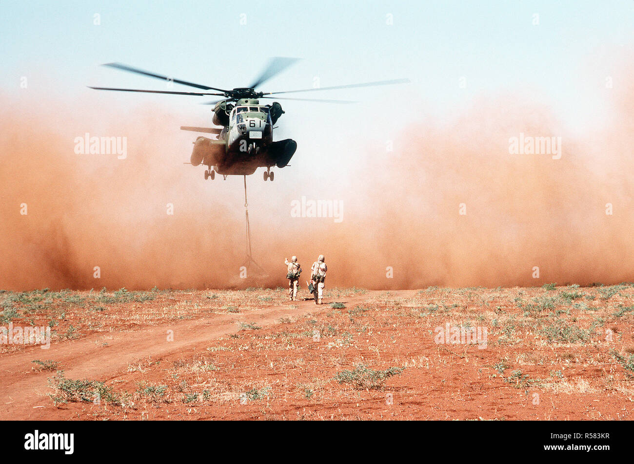 Ein Marine schweren Helikopter Squadron 363 (HMH-363) CH-53D Sea Stallion Hubschrauber liefert eine Last von Korn zu einem Feld außerhalb des Dorfes Maleel während der multinationalen Entlastung Bemühung Operation Restore Hope. Das Korn, durch Australien gespendet, wird anstelle der geflogenen geführt, weil der Verdacht besteht, dass die Straßen Konnossements zu das Dorf gefördert wurden. Stockfoto
