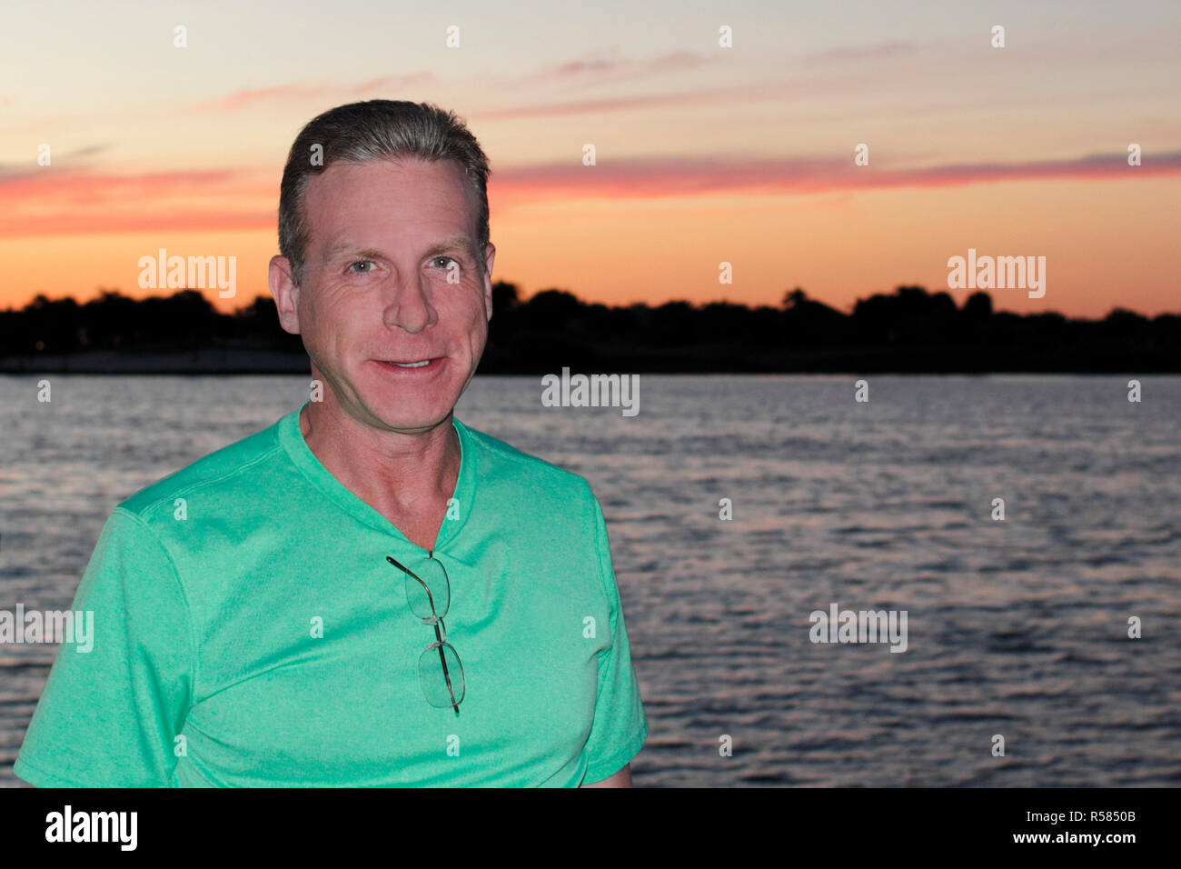 Mann lächelnd Profil mit Sonnenuntergang See Stockfoto