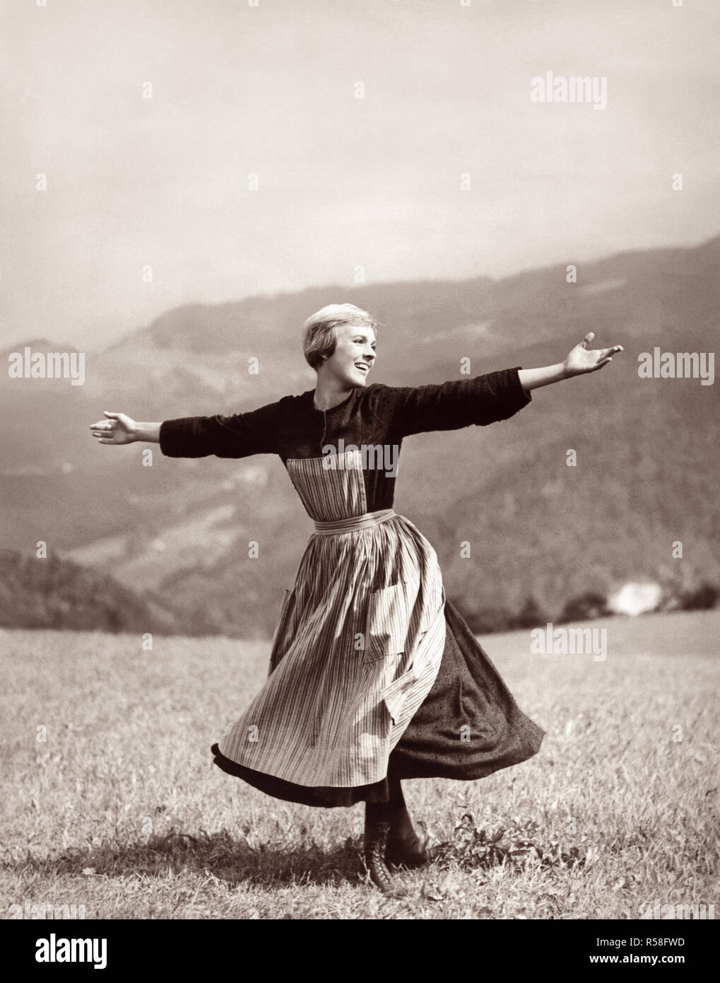 Julie Andrews twirling und singen auf einer Bergspitze Wiese in den Academy Award 1965 ausgezeichnete Film, der Klang der Musik. Stockfoto