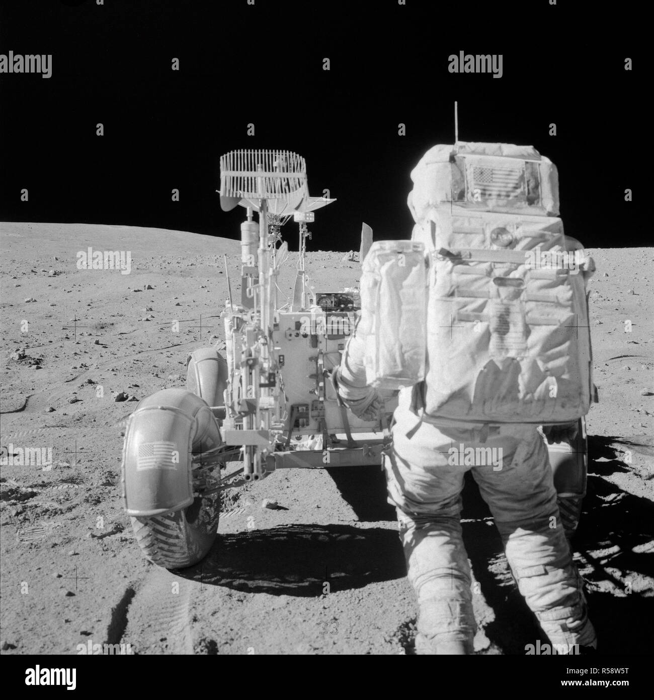 (22 April 1972) - - - Astronaut John W. Young, Kommandant der Apollo 16 Mondlandung Mission, erreicht für Werkzeuge in der Apollo Lunar Hand Tool Carrier am hinteren Ende des Lunar Roving Vehicle (LRV) während der zweiten Apollo 16 Extra Vehicular Activity (EVA) der Descartes Landeplatz. Stockfoto