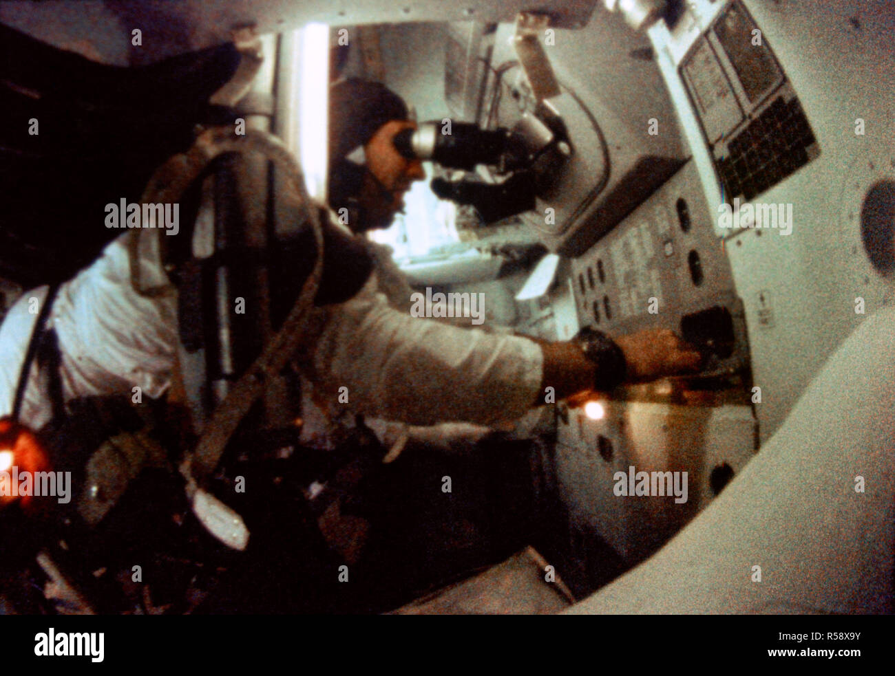 (21-27 Dez. 1968) - - - Astronaut James A. Lovell jr., Apollo 8 Befehl Modul Pilot, ist in der Führung der Apollo 8 Spacecraft Command Modul und Navigation Station während der Apollo 8 mission Lunar Orbit gesehen. Dieses Bild wurde von 16 mm Motion Picture Films. Stockfoto