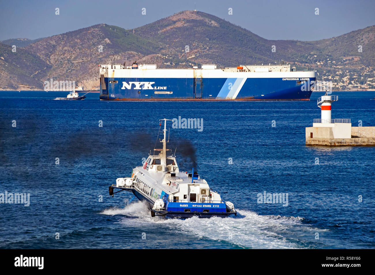 Hellenic Seaways Flying Dolphin 17 Ausfahrt aus dem Hafen von Piräus Athen Griechenland Europa mit NYK Line Capricornus Führer hinter Stockfoto