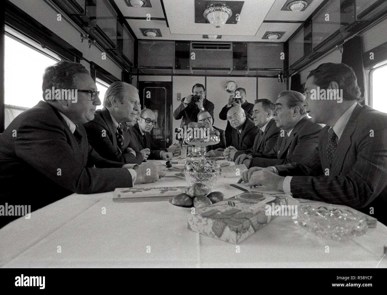 1974, November 23 - Sowjetische Zug - Union der Sozialistischen Sowjetrepubliken - Gerald R. Ford, Henry Kissinger, Helmut Sonnenfeldt, Botschafter Walter J. Stoessel, Leonid Breschnew, Andrei Gromyko, Botschafter Anatoli Dobrynin, Victor Sukhrodev; Andere in der amerikanischen und sowjetischen Kontingente - um den Tisch sitzen, reden - Reise in die Union der Sozialistischen Sowjetrepubliken (UDSSR) - Sitzung während der Zugfahrt nach Wladiwostok - (lokale Zeit); Stoessel (US-Botschafter in der UDSSR); Breschnew (Generalsekretär der UDSSR); Gromyko (Außenminister der UDSSR); Dobrynin (UDSSR Botschafter in t Stockfoto