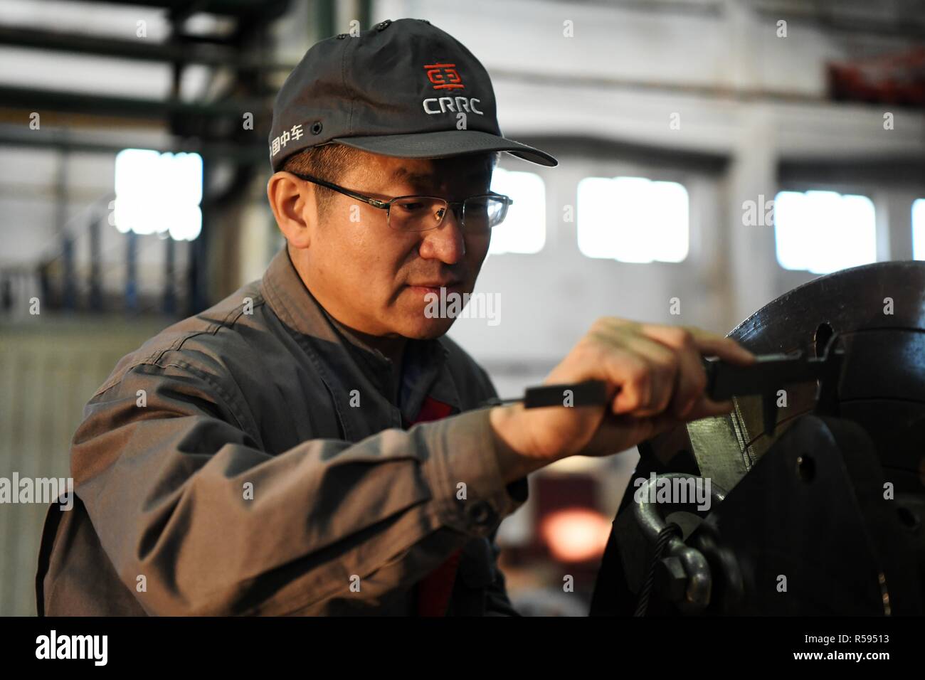 Harbin. 29 Nov, 2018. Zhu Wentao Maßnahmen eine bearbeitete Teil in der Werkstatt in Qiqihar, im Nordosten der chinesischen Provinz Heilongjiang, Nov. 29, 2018. Als leitender Techniker von China Eisenbahnrollmaterial Corporation (CRRC) Qiqihar Co.Ltd., Zhu hat Preise mehrfach für seine hervorragende betriebliche Leistung erhalten. Dass er ein Meister der Werkzeuge, ist er in der Lage, Stahl Schrotte so fein wie weniger als ein Siebtel der Durchmesser der normalen menschlichen Haares zu Drehbank. Credit: Wang Jianwei/Xinhua/Alamy leben Nachrichten Stockfoto