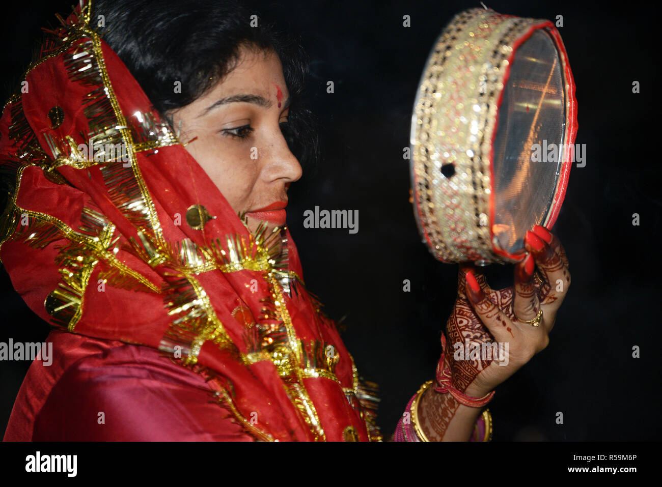 Frau im Mond durch ein Sieb während Karva Chauth Stockfoto