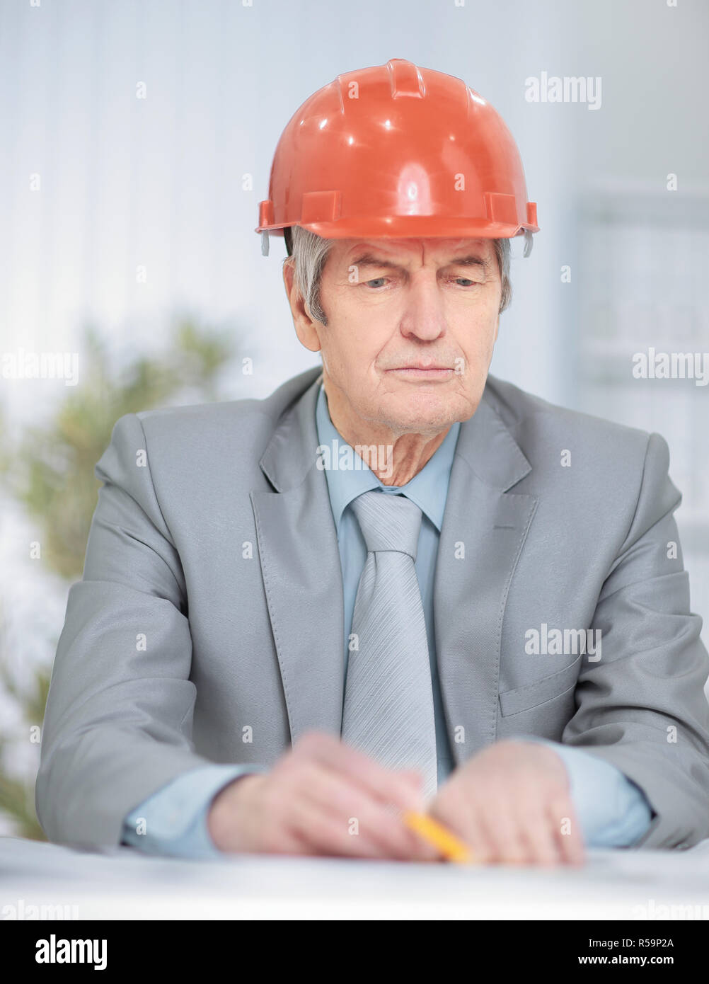 Porträt eines Senior Engineer an seinem Schreibtisch sitzen Stockfoto