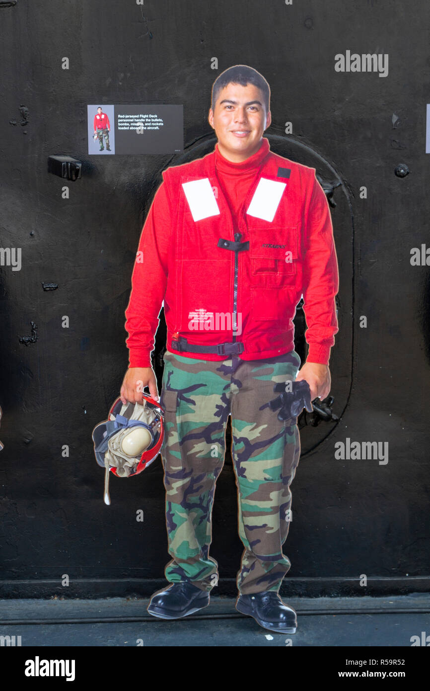 Rot - jerseyed Flight Deck Person (die Kugeln, Bomben, Raketen und Raketen Griff), USS Midway Museum, San Diego, California, United States. Stockfoto