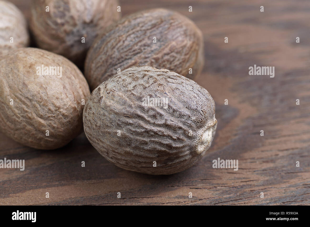 Haufen Muskatnuss auf einem hölzernen Hintergrund Nahaufnahme Stockfoto