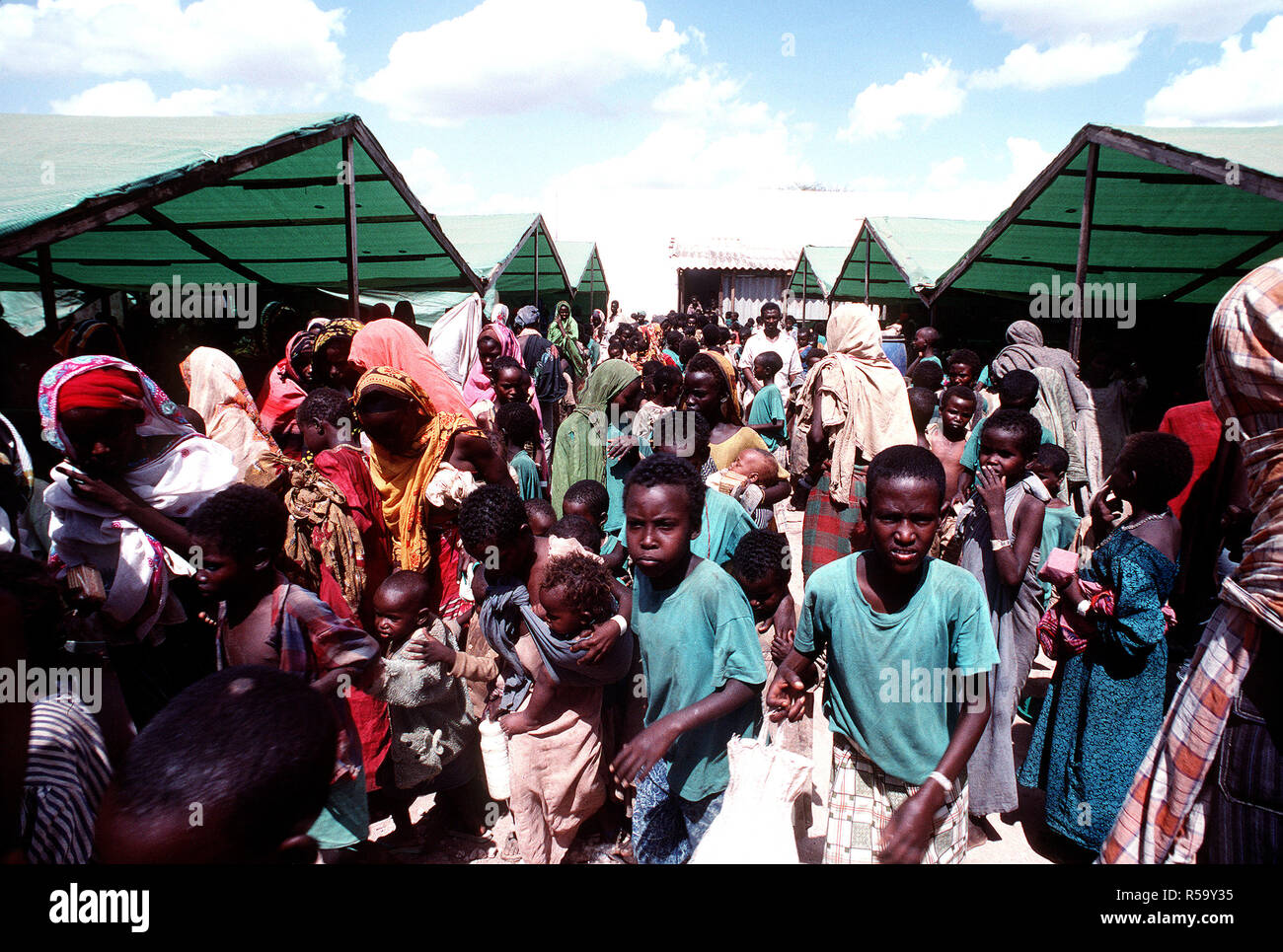 1993 - Somalis an der Sorge Ernährungszentrum sammeln während der multinationalen Entlastung Bemühung Operation Restore Hope. Das Zentrum wird von der irischen Hilfsorganisation Sorge betrieben. Stockfoto