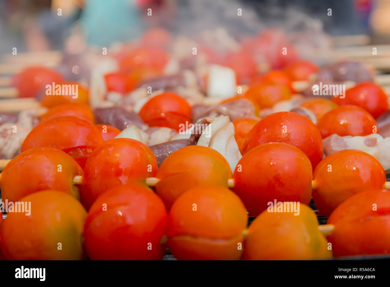 Huhn Herzen mit Tomate und Zwiebel kochen auf heißen Grill Stockfoto