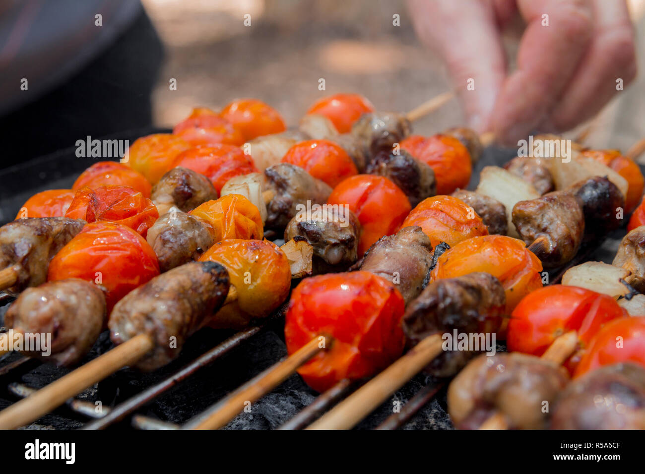 Huhn Herzen mit Tomate und Zwiebel kochen auf heißen Grill Stockfoto