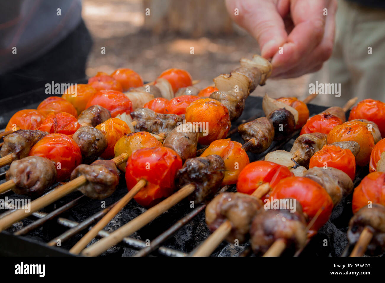 Huhn Herzen mit Tomate und Zwiebel kochen auf heißen Grill Stockfoto