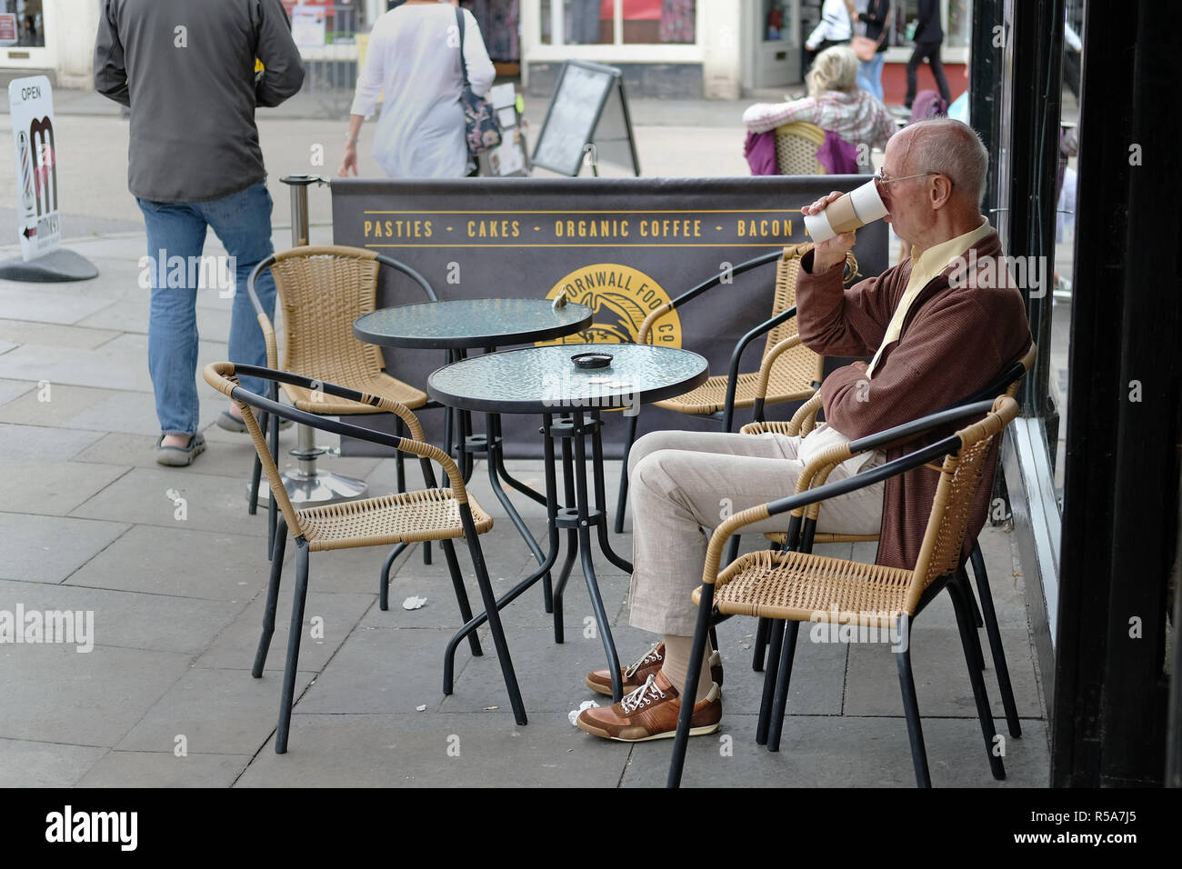 Ein alter Mann Kaffee trinken außerhalb einen Coffeeshop in Wells, Somerset, UK. Stockfoto