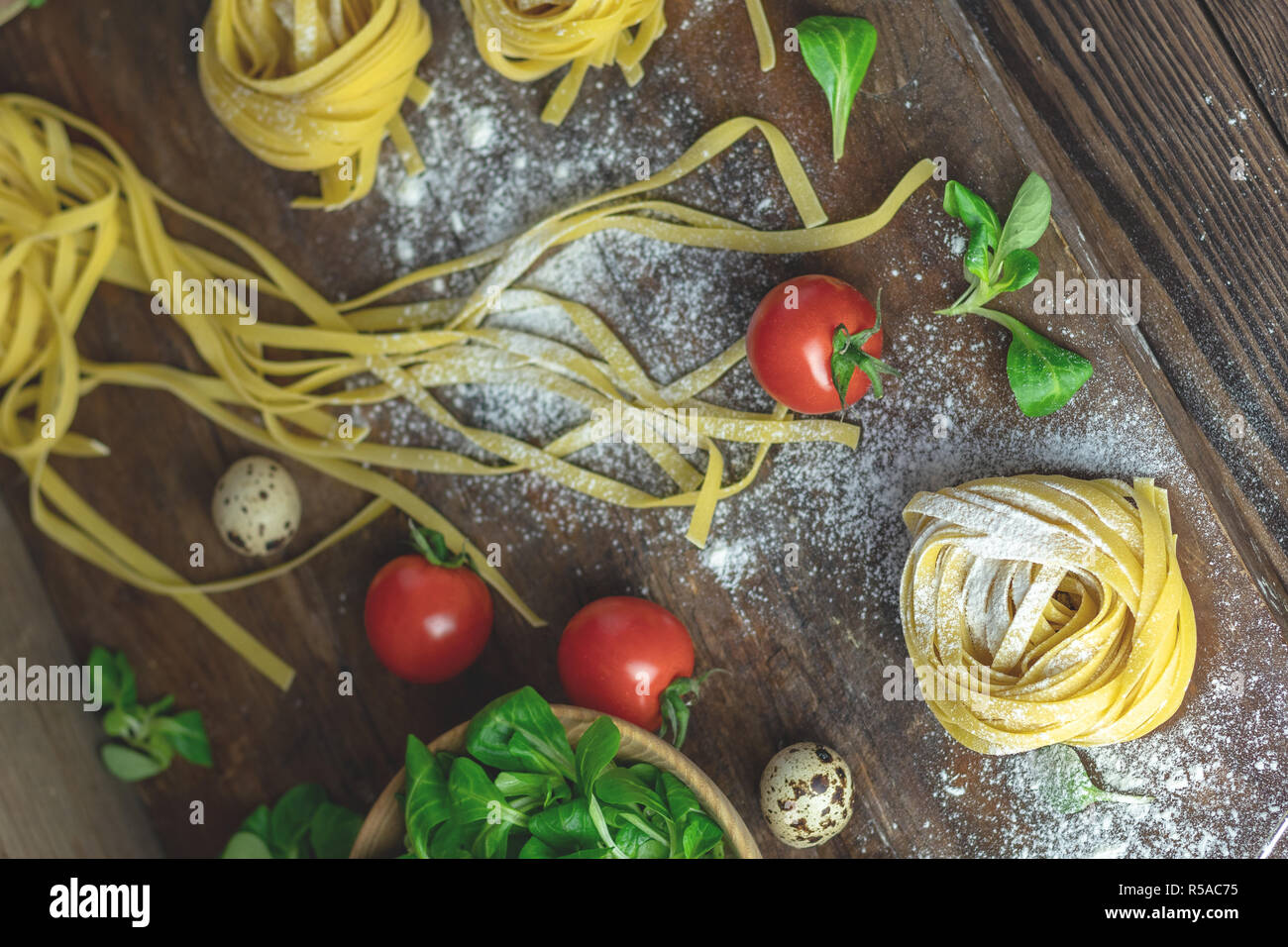 Raw hausgemachte italienische typische Pasta linguine Nudeln, Wachteleier, grüner Salat, Tomaten