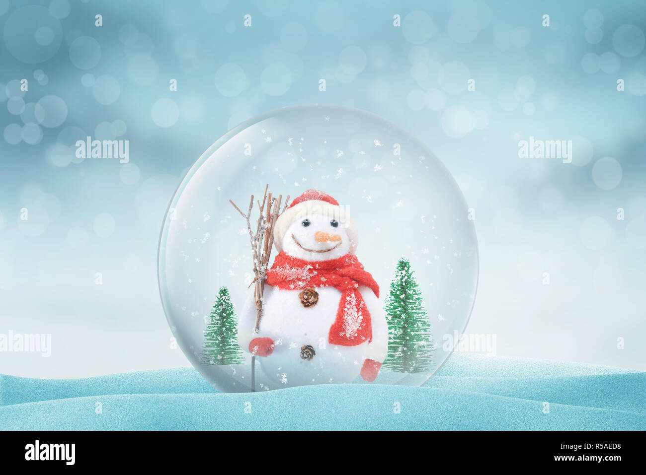 Weihnachten magic ball mit Schneemann und Bäume auf Schnee. Schneeflocken nad Bokeh im Hintergrund. Stockfoto