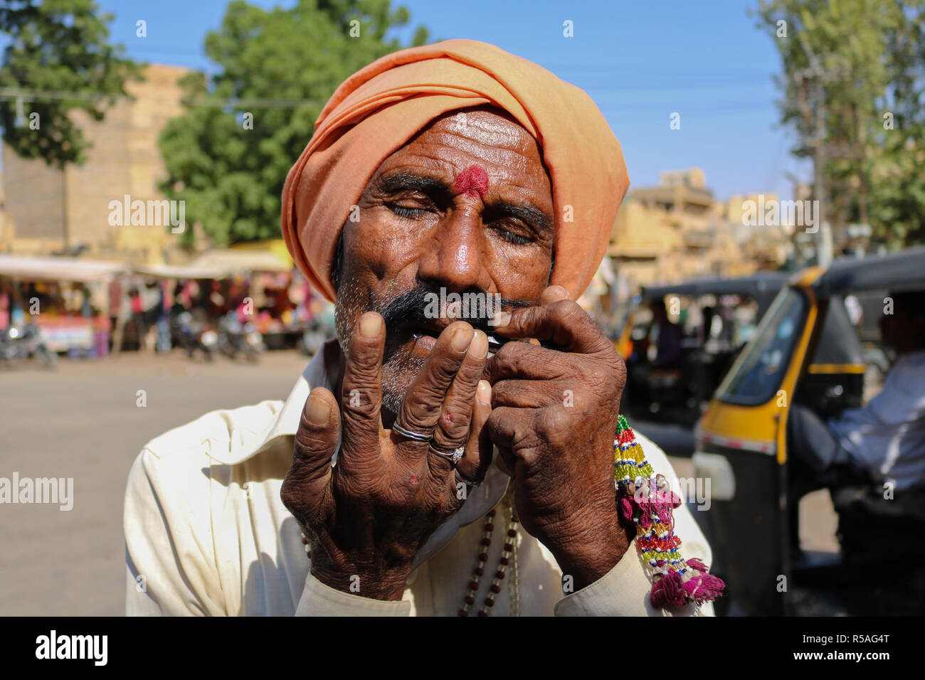 Mann spielt Mundharmonika an Mehrangarh Fort, Jodhpur, Rajasthan, Indien. Stockfoto
