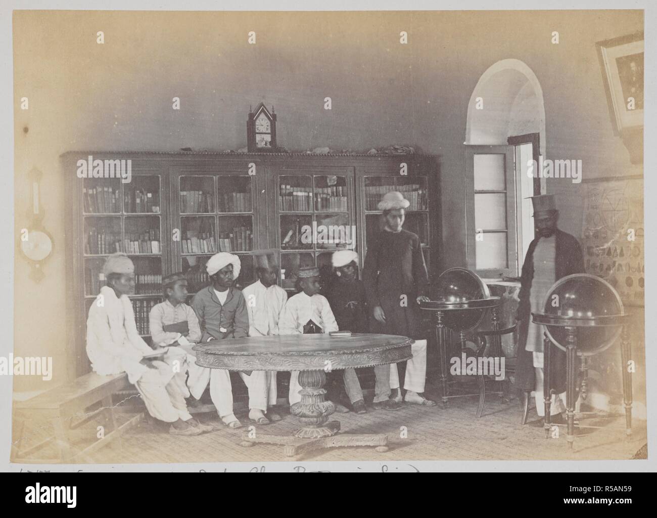 Schülerinnen und Schüler in einem Klassenzimmer in der Schule Anglo-Vernacular, Karachi. Eine kleine Gruppe von Schülern sitzen um einen Tisch, mit einem Lehrer stand neben einem Globus auf der rechten Seite. c. 1873. Foto. Quelle: Foto 1000/46 (4650). Autor: Michie und Unternehmen. Stockfoto