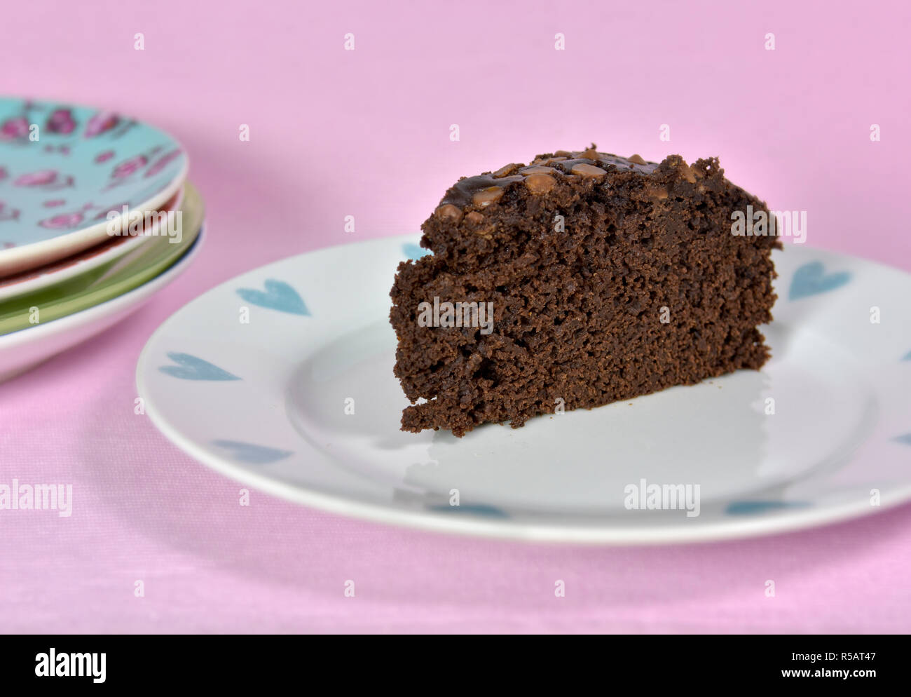 Moist Schokolade Kuchen auf ziemlich Platte ohne Eier und mit Pflanzenöl statt Butter gemacht. Vor einem rosa Hintergrund. Stockfoto